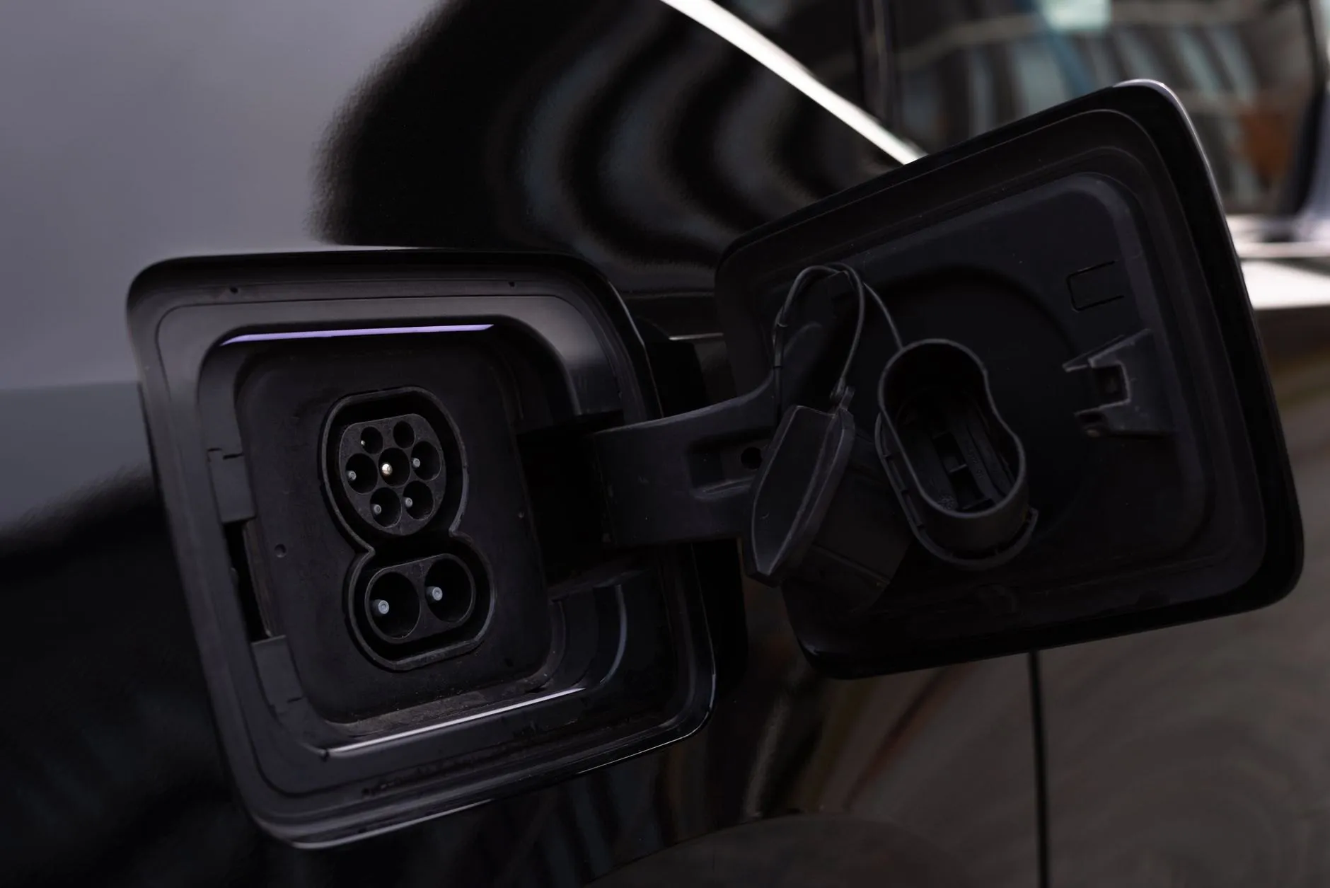 The open charging inlet on the side of an electric car